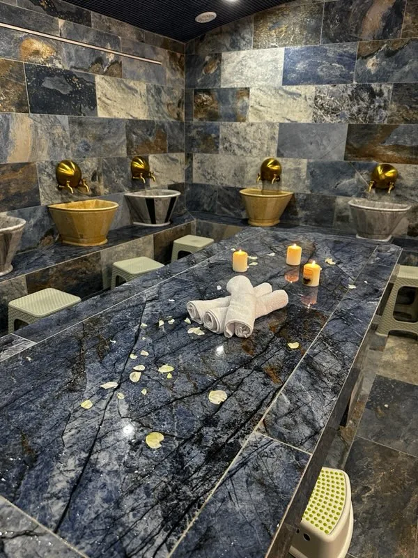 La table de gommage en marbre bleu, bougies et serviettes